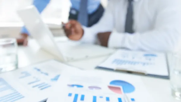 Business people looking over printed charts.