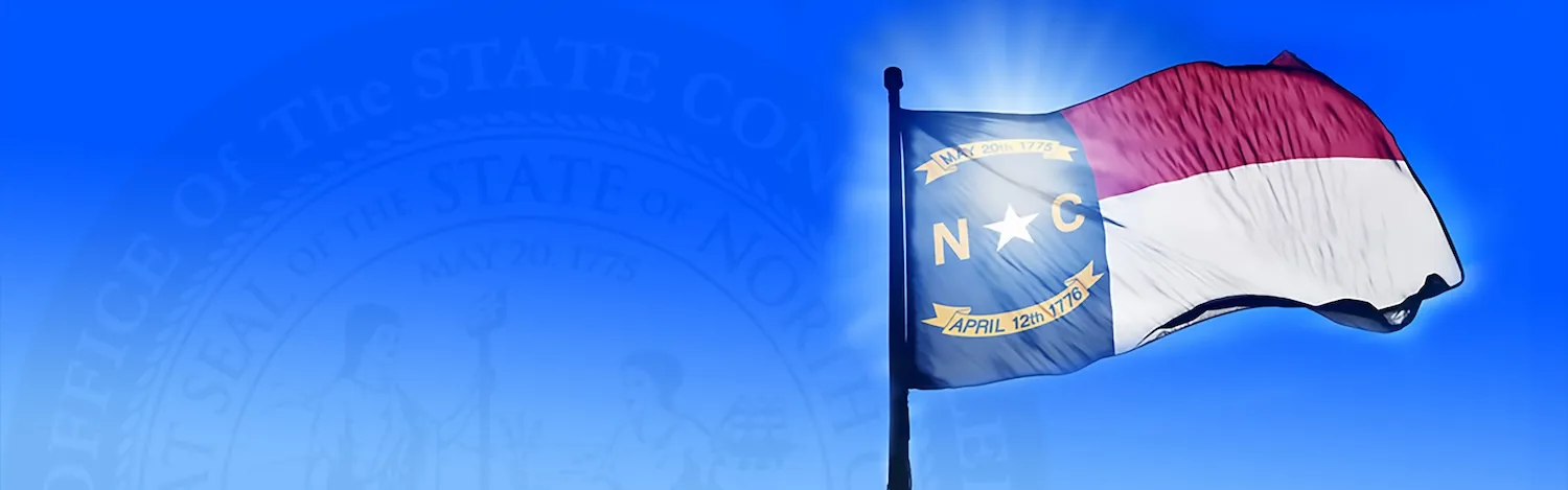 NC state flag flying against a blue sky.